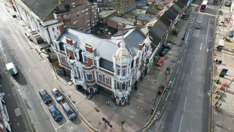 Historic building in London with ornate architecture, surrounded by streets and parked vehicles, illustrating the importance of preserving historical properties.