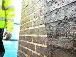 Mason applying tuck pointing technique on brickwork, showcasing craftsmanship and restoration